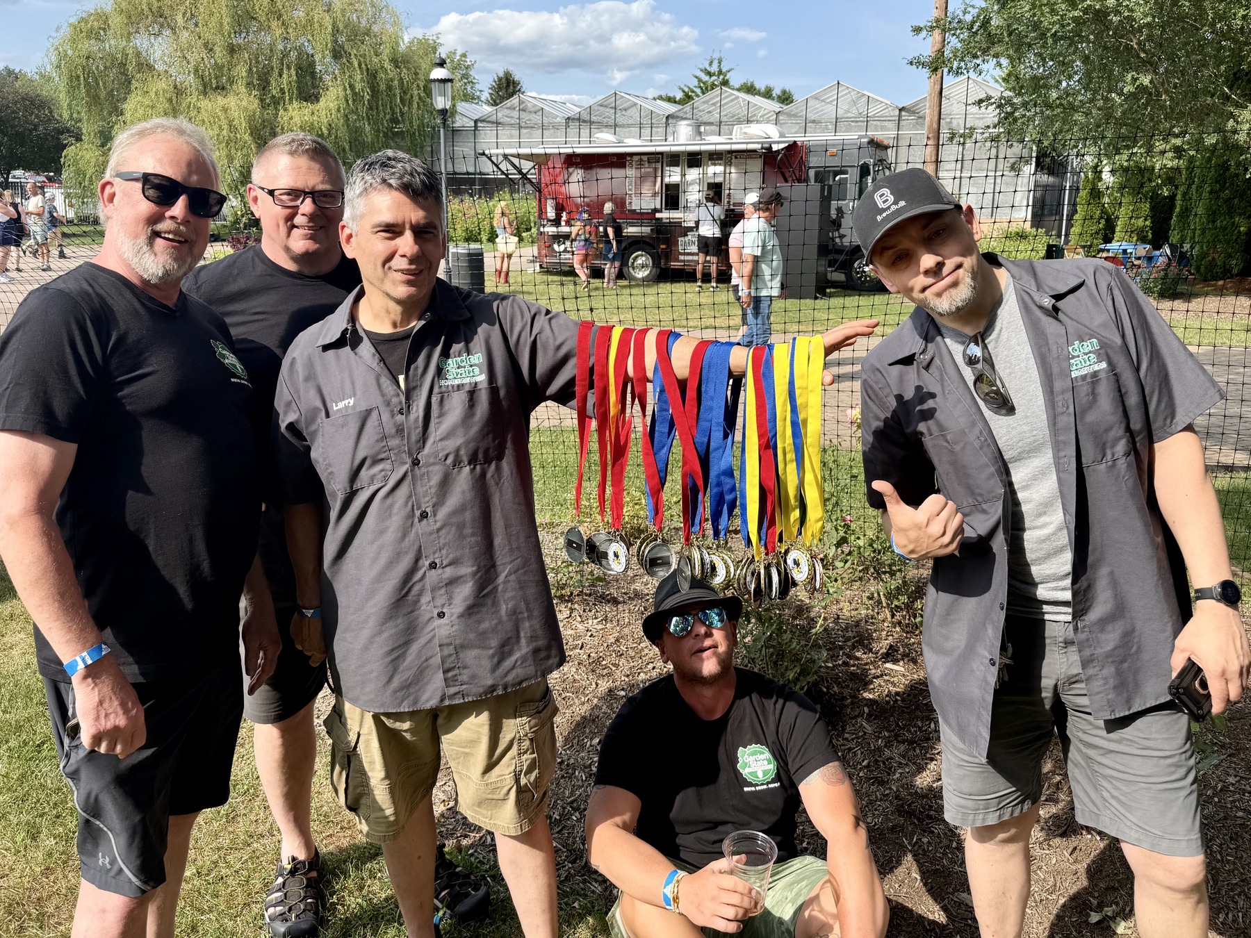 Brewers posing near a row of competition medals